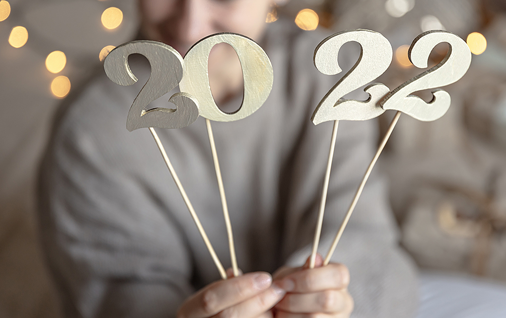 Close Up Of Wooden Numbers 2022 On Sticks In Female Hands On Blurred Background With Bokeh.